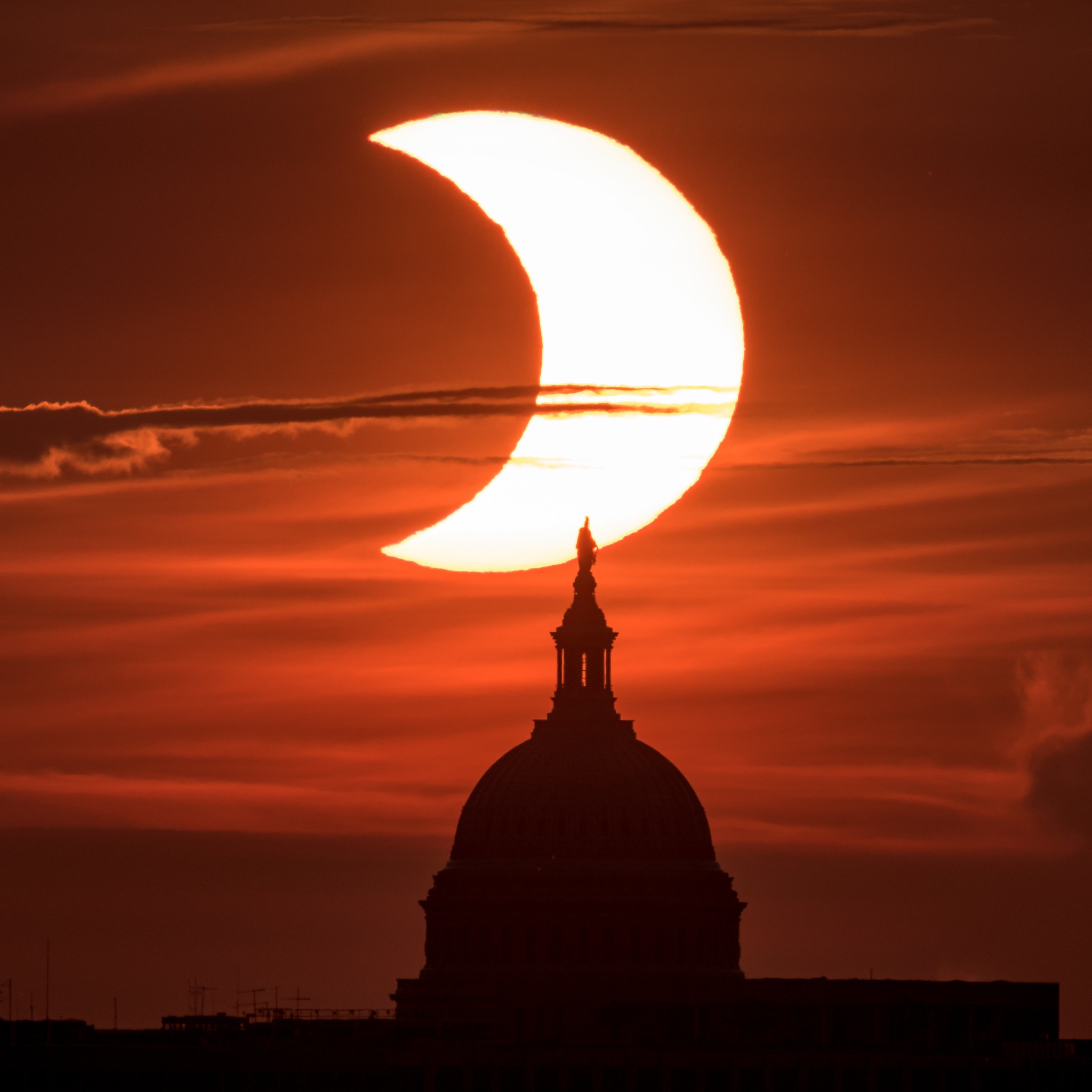 Nasa divulga imagens do eclipse solar anular visto parcialmente nos EUA. Acima: Fenômeno é visto acima do Capitólio dos Estados Unidos. Imagem captada na cidade de Arlington, Virgínia, e escolhida como Imagem do Dia pela Nasa (Foto: NASA/Bill Ingalls)