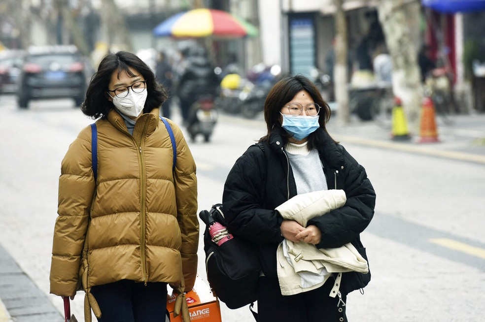 Mulheres usam máscaras enquanto andam por uma rua em Hangzhou, na província de Zhejiang, leste da China, na terça-feira, 21 de janeiro de 2020 — Foto: Chinatopix/AP