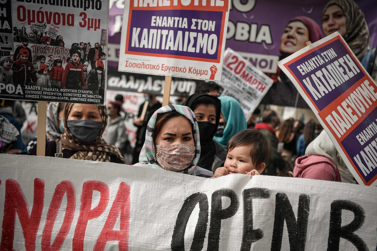 Mulheres e famílias refugiadas, exigem respeito aos seus direitos em protesto no Dia Internacional da Mulher, na capital grega AtenasAFP