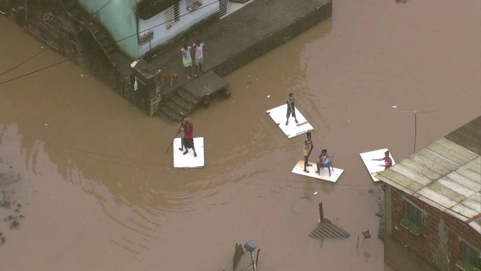 Moradores do bairro da Muribeca, em Jaboatão dos Guararapes, utilizam jangadas improvisadas neste sábado (22) (Foto: Reprodução/TV Globo)