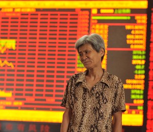 Investidora observa queda nas ações na Bolsa de Xangai e em outras bolsas de valores asiáticas em centro de Fuyang, na província de Anhui, China (Foto: ChinaFotoPress/ChinaFotoPress via Getty Images)