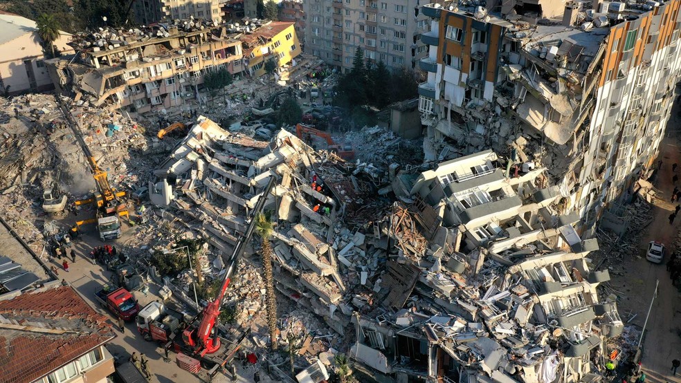 Equipes de resgate procuram pessoas enquanto guindastes removem escombros de edifícios destruídos na Turquia durante o terremoto de 6 de fevereiro de 2023. — Foto: Hussein Malla / AP Photo