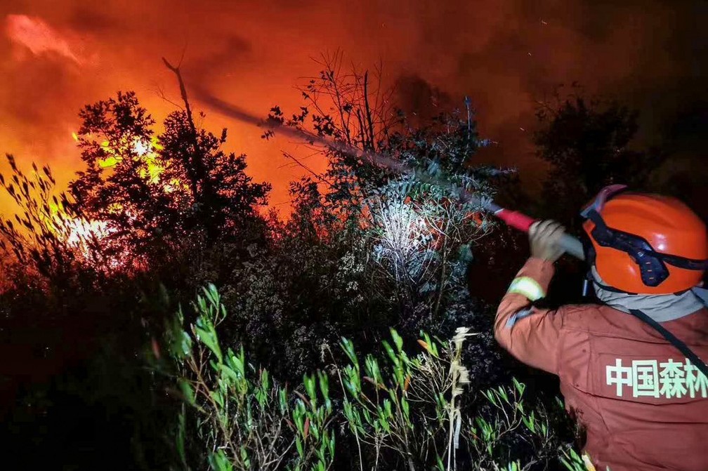 Bombeiro atua no combate a um incêndio florestal em Xichang, na província de Sichuan, no sudoeste da China (31) — Foto: STR/AFP