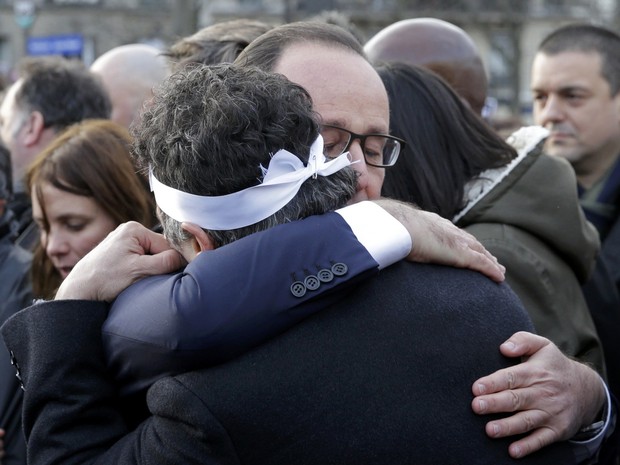 O presidente francês, François Hollande, abraçou durante a marcha o médico Patrick Pelloux, colaborador do Charlie Hebdo que chegou ao jornal pouco depois do ataque à redação (Foto: REUTERS/Philippe Wojazer)