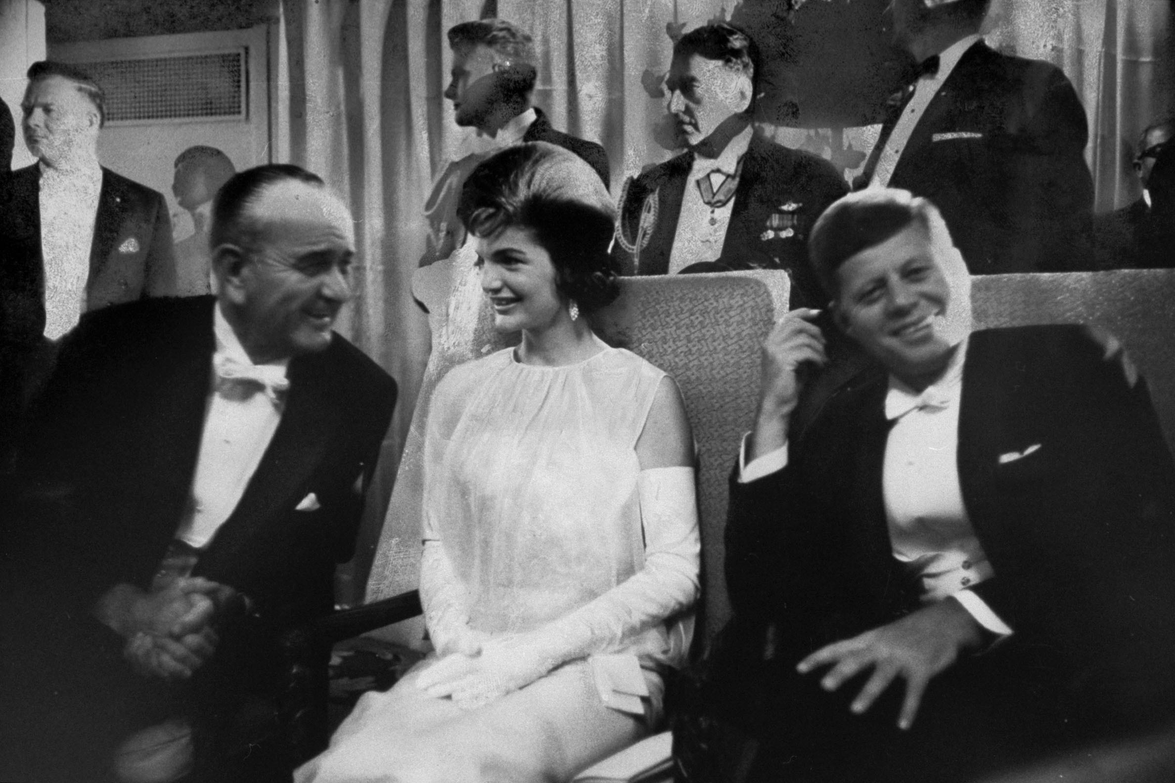 Jackie Kennedy de vestido de chiffon no baile da posse de John F. Kennedy, em 1961. À esquerda, o vice Lyndon B. Johnson (Foto: Getty)
