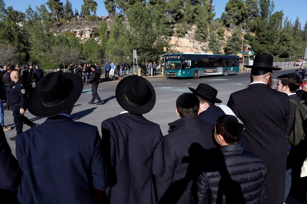 Homens judeus ultraortodoxos olham para a cena de uma explosão em um ponto de ônibus em Jerusalém — Foto: Ammar Awad/REUTERS