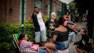 Pessoas tentam se acomodar na fila à espera do recadastramento do CadÚnico no Poupa Tempo em Bangu, Zona Oeste do Rio — Foto: Brenno Carvalho/Agência O Globo