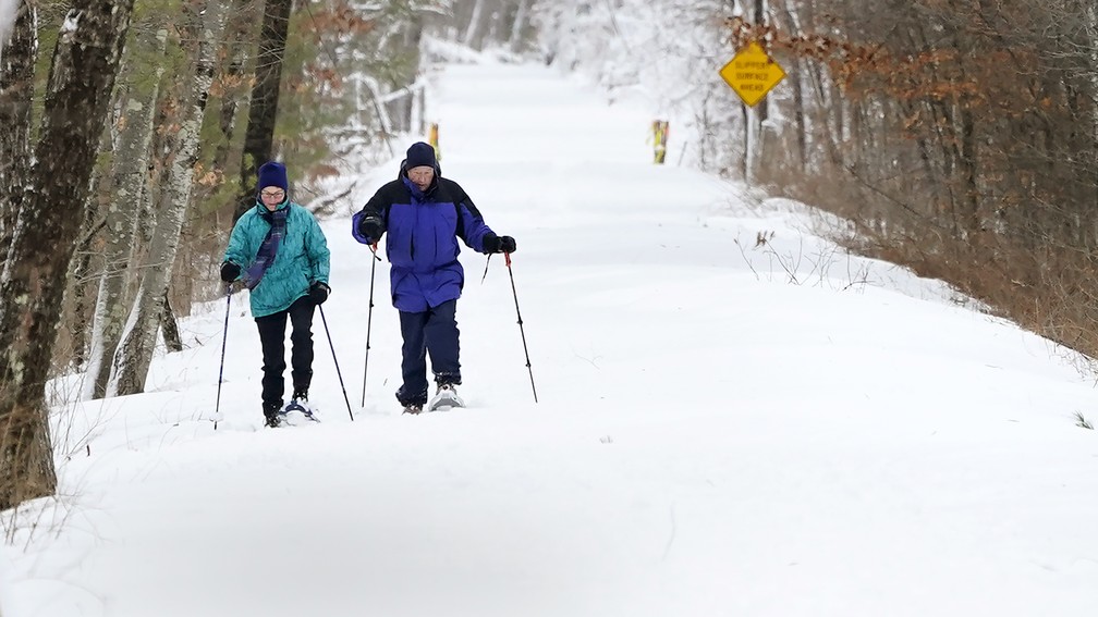 Casal caminha pela neve em New Hampshire depois da nevasca que atingiu a costa Leste dos EUA, em foto de 2 de fevereiro de 2021 — Foto: Charles Krupa/AP