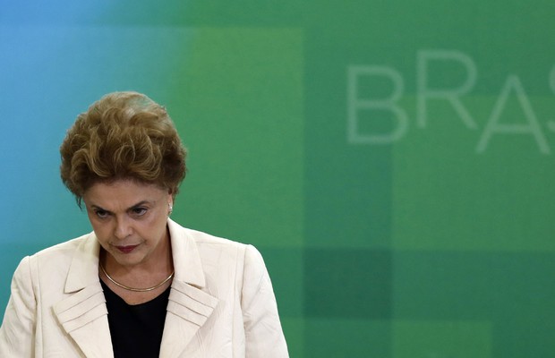 A presidente Dilma Rousseff observa o ex-presidente Luiz Inácio Lula da Silva assinar o termo que o nomeia oficialmente ministro da Casa Civil, durante cerimônia de posse dos novos ministros no Palácio do Planalto, em Brasília (Foto: Igo Estrela/Getty Images)