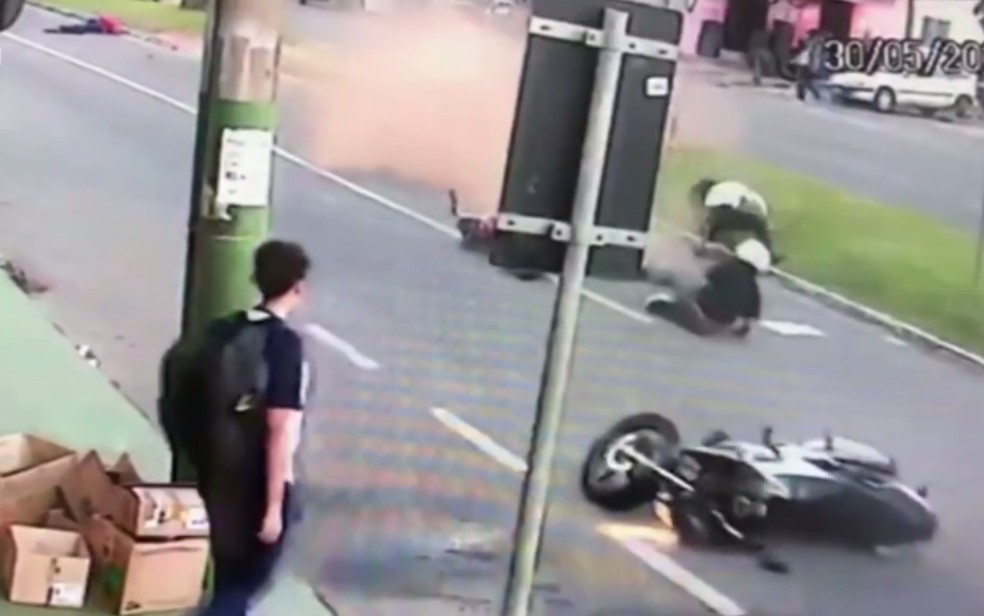 Imagem mostra estudante e os dois motociclistas cados em avenida em Anpolis, Gois  Foto: Reproduo/TV Anhanguera