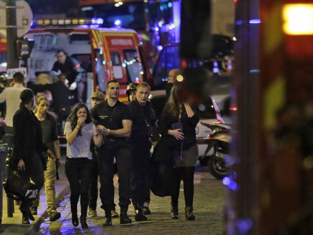 Pessoas saem em choque da casa de shows Bataclan, alvo de ataque terrorista em Paris (Foto: Kenzo Tribouillard/AFP)