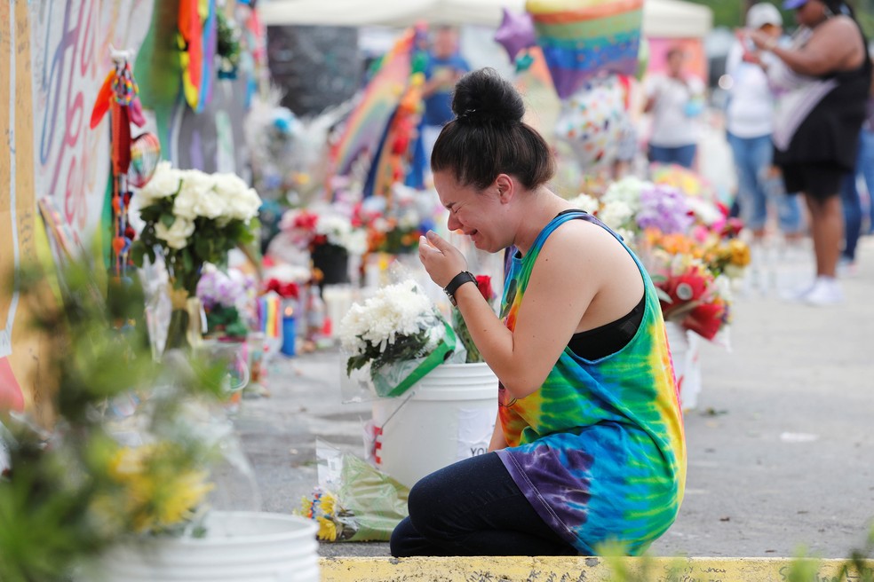 Jovem chora nesta segunda-feira (12) ao visitar o memorial às vítimas do ataque na boate gay Pulse, em Orlando, nos EUA (Foto: REUTERS/Scott Audette )