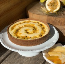Cheesecake de frutas amarelas, com calda de manga, maracujá e carambola e lascas de coco fresco da Bendita Tortas