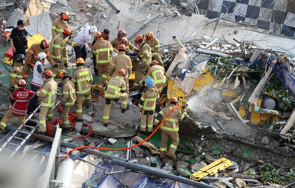 Bombeiros procuram por sobreviventes após prédio desabar em Gwangju, na Coreia do Sul, em 9 de junho de 2021. Edifício estava sendo demolido. — Foto: Yonhap via AP