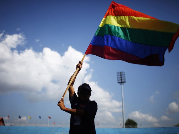 Membro da comunidade LGBT de Catmandu ergue uma bandeira do orgulho gay na cerimônia de abertura da 1ª edição dos Jogos LGBT do Sul da Ásia, na capital do Nepal. (Foto: Niranjan Shrestha/AP)