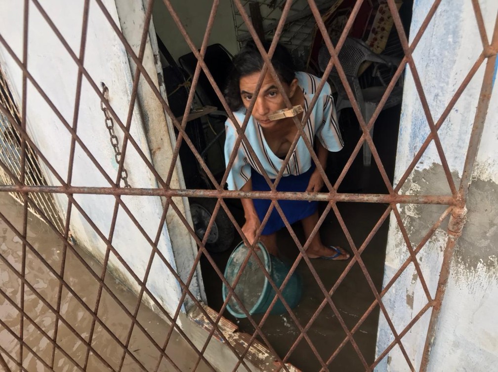 Moradora tira água de dentro de casa no bairro Planalto, na Zona Oeste de Natal — Foto: Geraldo Jerônimo/Inter TV Cabugi