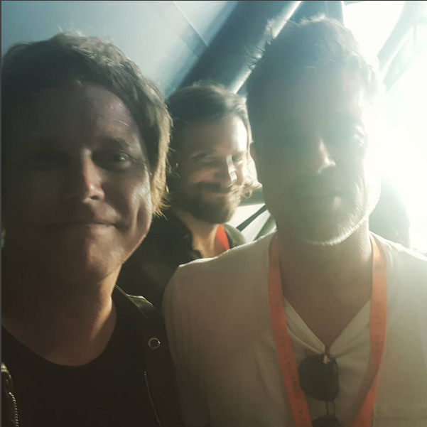 Chris Simmons com Brad Pitt e Bradley Cooper ao fundo (Foto: Reprodução/Instagram)