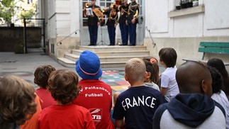 Alunos ouvem Guarda Republicana Francesa no pátio no primeiro dia do novo ano letivo na escola Poulletier, em Paris  — Foto: EMMANUEL DUNAND / AFP