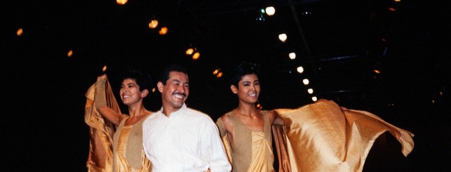 O estilista japonês Issey Miyake (centro) e suas modelos cumprimentam o público no fim do desfile de apresentação de moda prêt-à-porter Primavera-Verão 1985, em 22 de outubro de 1984, em Paris. — Foto: PIERRE GUILLAUD