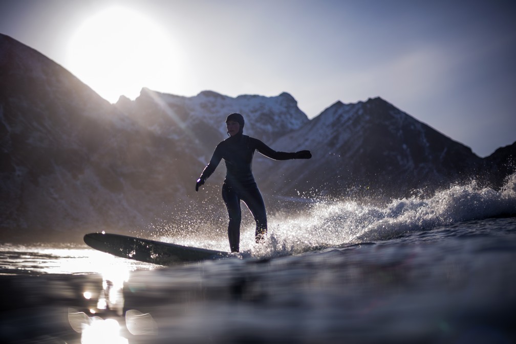 Surfista se aventura nas águas da praia de Unstad, a temperaturas negativas (Foto: Olivier Morin/AFP)