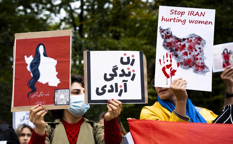 Manifestantes seguram cartazes durante manifestação contra o regime iraniano em frente à Câmara dos Deputados em Haia