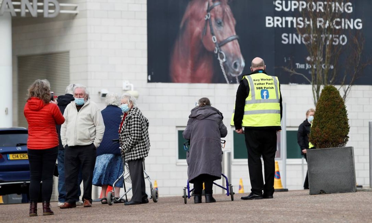 As pessoas chegam ao Epsom Downs Racecourse, na abertura como um centro de vacinação em massa, em Epsom, sul da Inglaterra — Foto: ADRIAN DENNIS / AFP