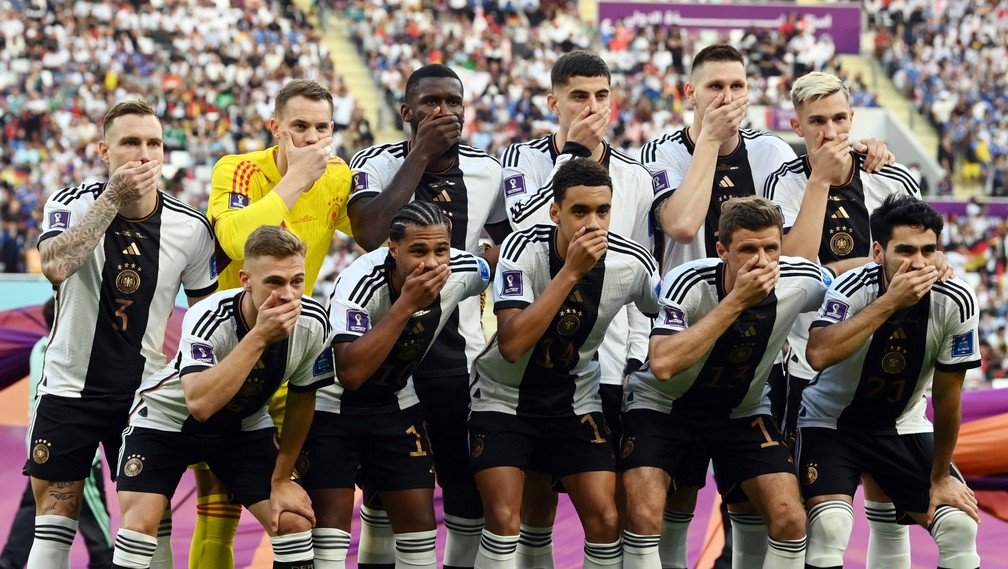 Jogadores da Alemanha tapam a boca em protesto contra a proibição da Fifa ao uso de braçadeiras 'One Lonve', na estreia na Copa do Catar contra o Japão, em 23 de novembro de 2022. — Foto: Annegret Hilse/ Reuters