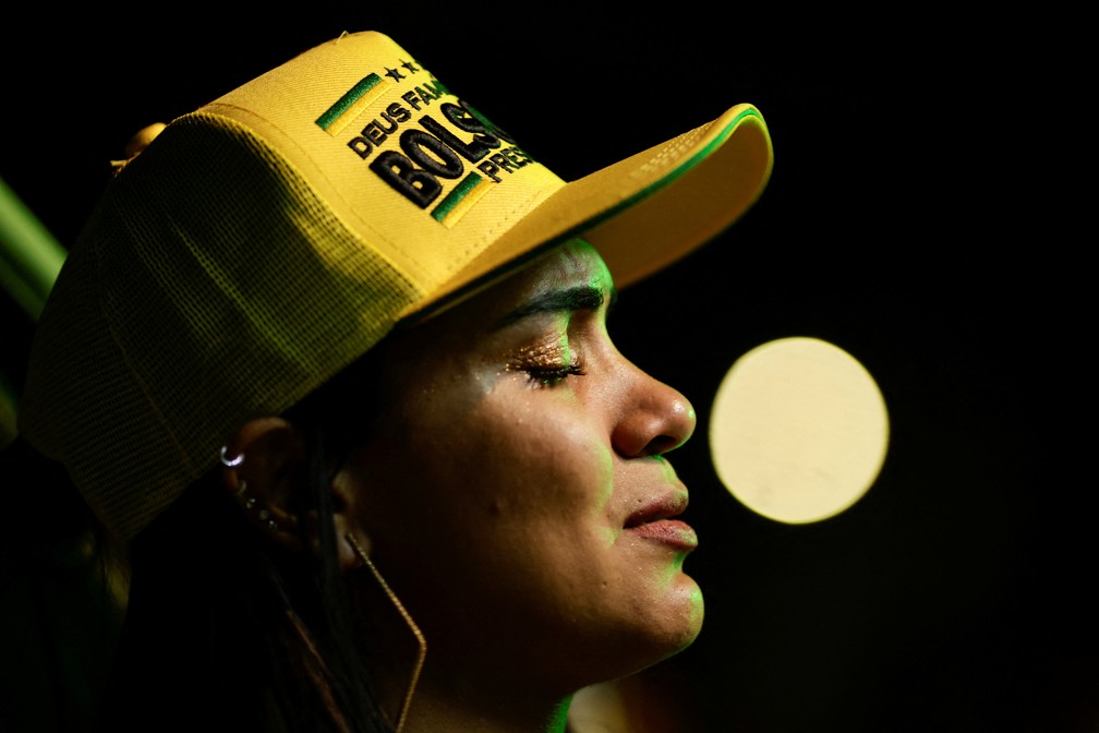 Eleitora com chapéu de Bolsonaro acompanha apuração da eleição em Brasília — Foto: REUTERS/Ueslei Marcelino