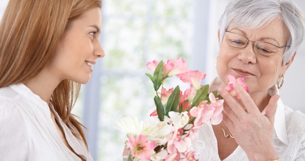 Mulher entregando flores para a sogra (Foto: Shutterstock)