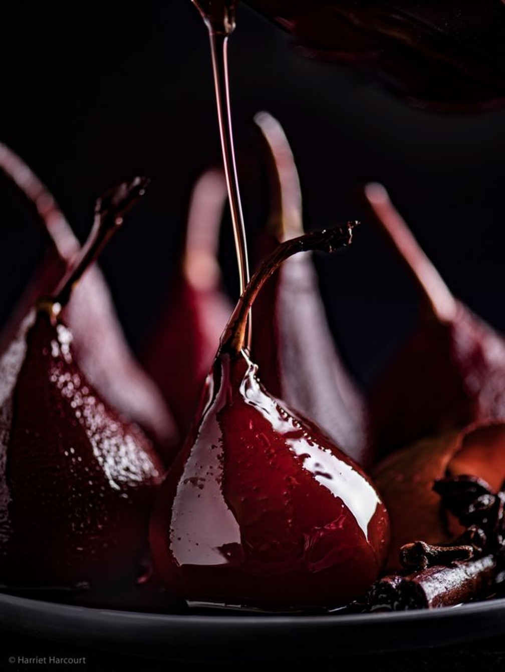 "Derramando a calda de vinho com especiarias sobre as peras escaldadas antes de servir." — Foto: HARRIET HARCOURT