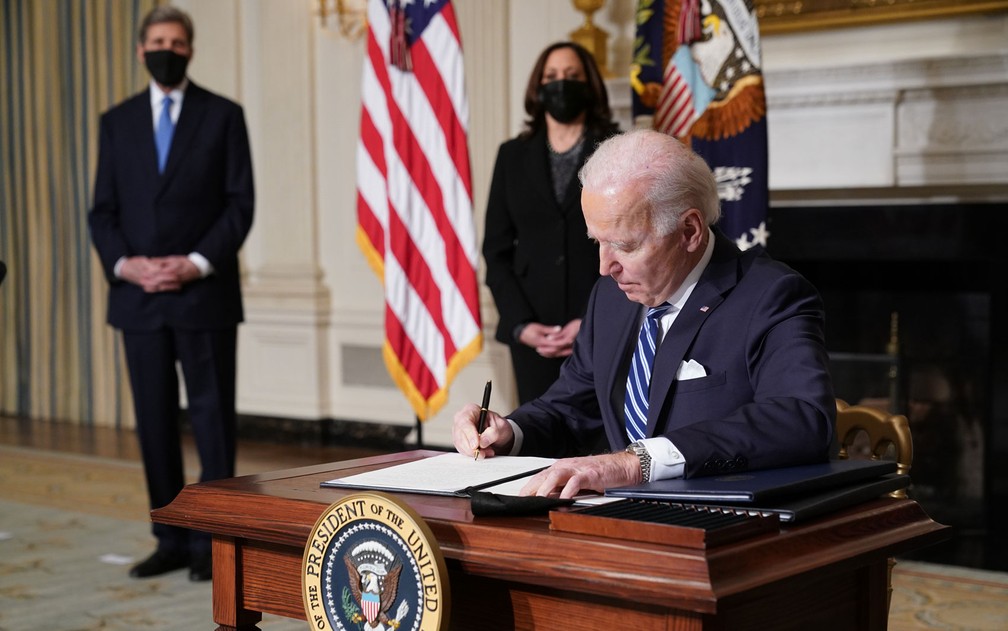 O presidente dos EUA, Joe Biden, assina atos executivos sobre meio ambiente, ao lado da vice-presidente, Kamala Harris, e do enviado especial presidencial para o Clima, John Kerry, na Casa Branca, na quarta-feira (27) — Foto: Mandel Ngan/AFP