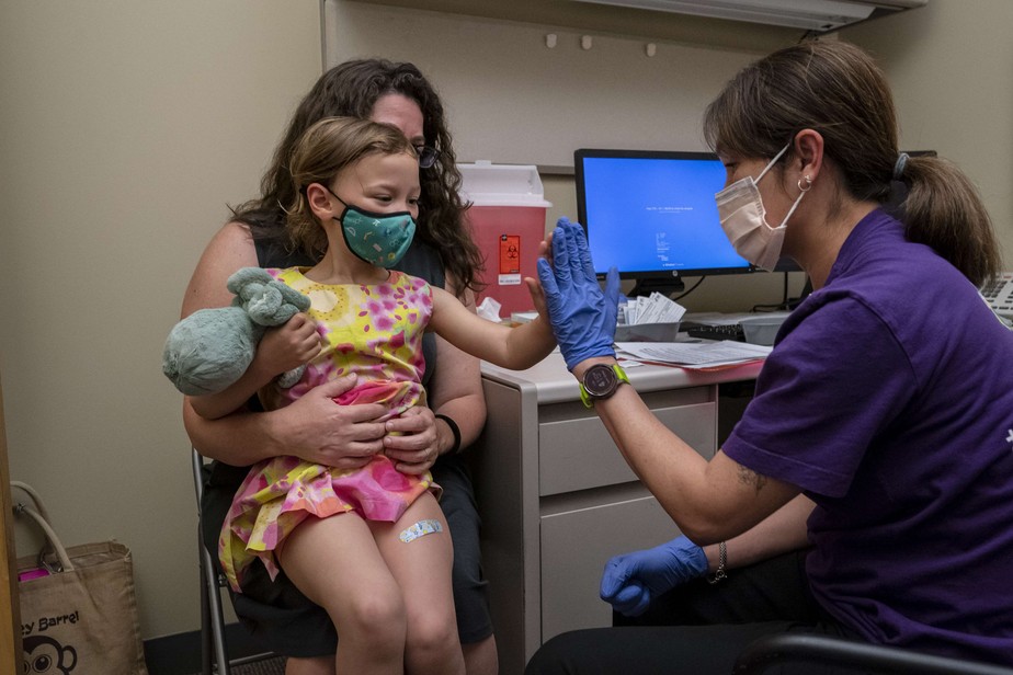Menina de três anos comemora após receber primeira dose da vacina da Pfizer em Seattle, nos Estados Unidos.