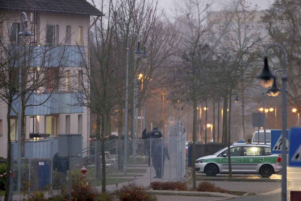 Carro de polícia é visto nesta quarta-feira (15) em frente a centro de imigrantes da cidade de Bamberg, após incêndio atingir o local (Foto: Daniel Karmann/dpa via AP)