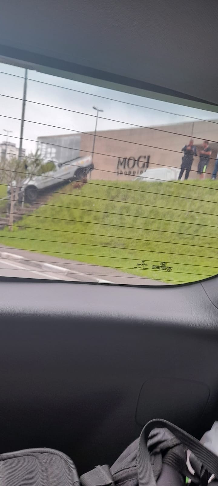 Motorista perde o controle, bate em poste e escada e veículo fica 'pendurado' em canteiro central em Mogi