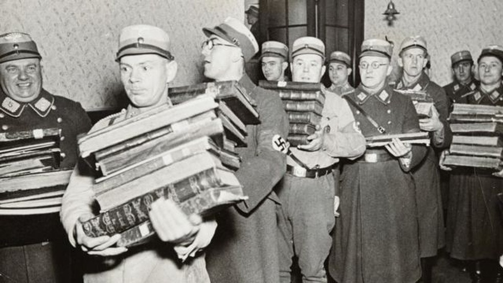 Oficiais nazistas carregando livros, supostamente para serem queimados — Foto: YAD VASHEM PHOTO ARCHIVE/via BBC