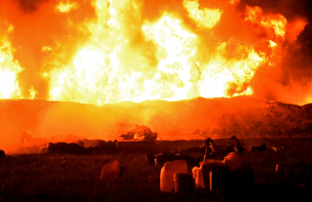 Fogo consome local da explosão de um oleoduto no México, na noite de sexta-feira (18). — Foto: Francisco Villeda/AFP