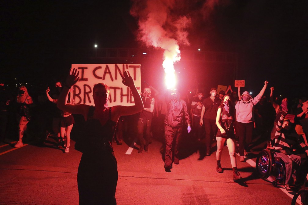 Manifestantes seguram tochas e um cartaz com a frase 'eu não consigo respirar', dita por George Floyd antes de morrer, durante protesto pela morte dele em Portland, no Oregon, na sexta-feira (29). — Foto: Dave Killen/The Oregonian via AP