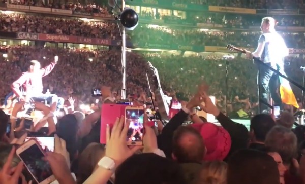 O cantor Chris Martin observando o fã do Coldplay sendo levado ao palco do show da banda (Foto: YouTube)