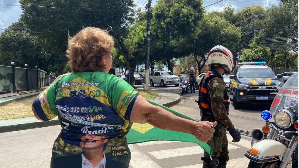 Apoiadora se posicionou em frente ao Comando Militar da Amazônia para ver Bolsonaro passar.  — Foto: Ruthiene Bindá/Rede Amazônica