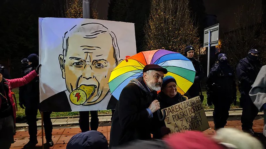 Manifestantes seguram cartaz que diz 'Jarek, você transformou a Polônia em um bordel e as mulheres em incubadoras'