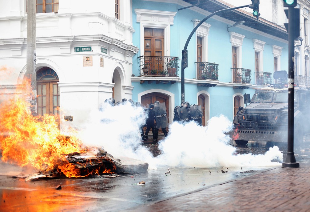 Manifestante ateiam fogo em colchões durante protestos contra alta nos combustíveis em Quito, no Equador — Foto: Daniel Tapia/Reuters