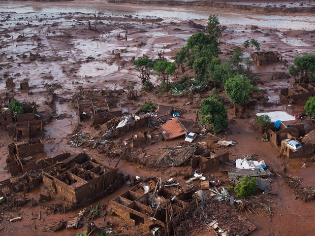 06/11 - Carros e destroços de casas são vistos em meio a lama após o rompimento de uma barragem de rejeitos da mineradora Samarco no Distrito de Bento Rodrigues, no interior de Minas Gerais (Foto: Felipe Dana/AP)