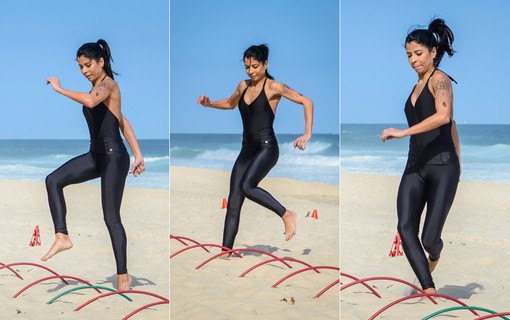 Exercício de lateralidade: Anna passa os pés pelos aros na areia. Ajuda a ter noção do espaço e equilíbrio