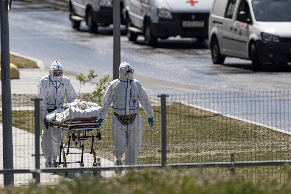 Profissionais de saúde carregam paciente com suspeita de ter Covid-19 para um hospital em Kommunarka, nos arredores de Moscou, em 26 de junho de 2021, em meio à pandemia do novo coronavírus (Covid-19) na Rússia — Foto: Alexander Zemlianichenko/AP