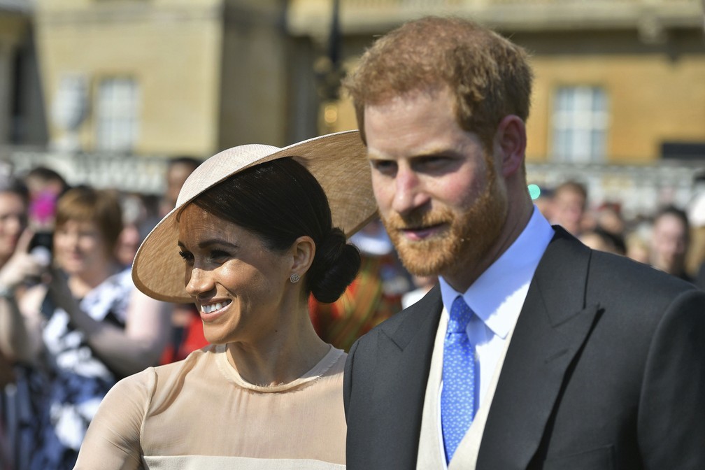 Meghan e Harry, duquesa e duque de Sussex, aparecem nesta terÃ§a-feira  (22) em evento no PalÃ¡cio de Buckingham, em Londres, trÃªs dias apÃ³s seu casamento em Windsor (Foto: Dominic Lipinski/Pool Photo via AP)