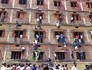 Pais escalam prédio para dar cola aos filhos (AP Photo/Press Trust of India)