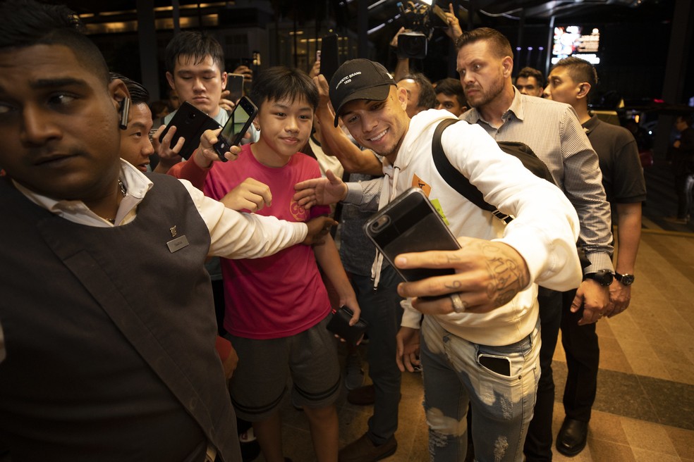 Everton Cebolinha tira foto com fã na chegada ao hotel da seleção brasileira na Malásia — Foto: Lucas Figueiredo/CBF