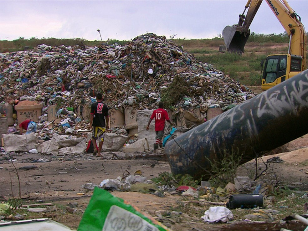 Trabalhadores juntam materiais no Aterro de Aguazinha, em Olinda (Foto: Reprodução/TV Globo)
