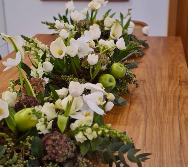 Crie um centro da mesa posta com flores brancas, diferentes folhagens, suculentas e maçãs verdes (Foto: Studio Magnólia / Divulgação)