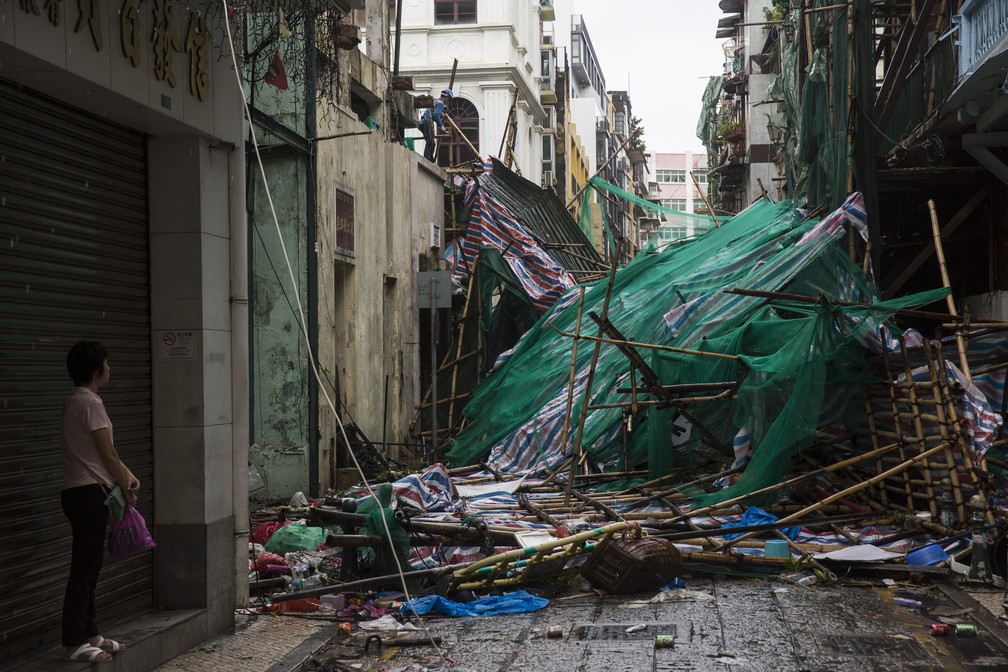 Mulher observa estrago causado pelo tufão Mangkhut nesta sgunda-feira (17) em Macau, na China — Foto: Vincent Yu/AP Photo